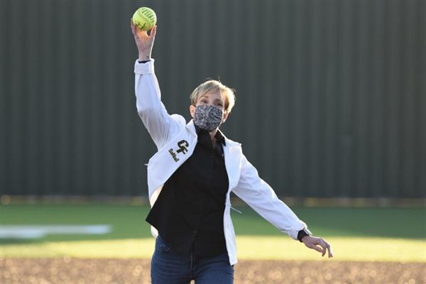 Trustee Julie Hinaman throwing the first pitch at a Cypress Falls High School softball game